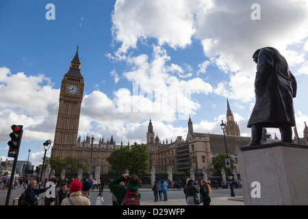 Crowds of tourists in front of the statue of Winston Churchill in Parliament Square, London, with Big Ben, London. Stock Photo