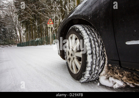 Car with winter tires drives on a street, completely covered with snow. Stock Photo