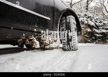 Car with winter tires drives on a street, completely covered with snow. Stock Photo