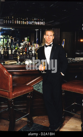 Portrait of young man at bar, in tuxedo Stock Photo