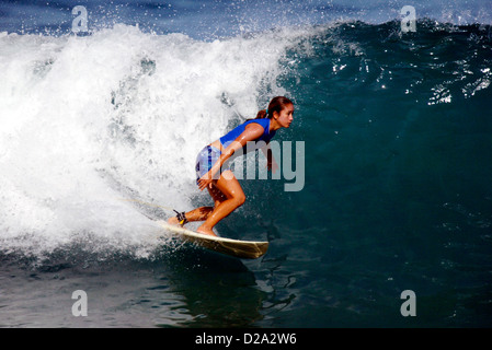 Hawaii, Oahu. Girl Surfing 'Gas Chambers'. Stock Photo