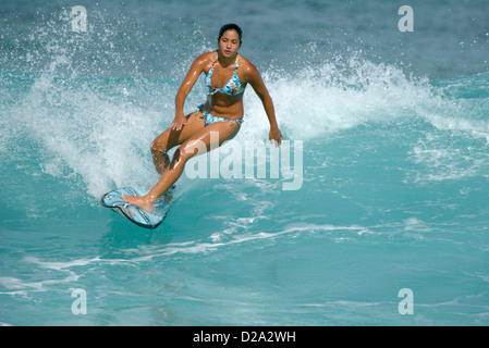 Hawaii, Oahu. Girl Surfing At 'Gas Chambers' Stock Photo