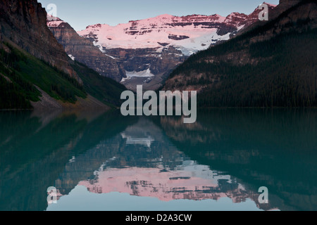 Morning alpenglow on Mount Victoria reflected in Lake Louise, Banff National Park, Canadian Rockies, Alberta, Canada.