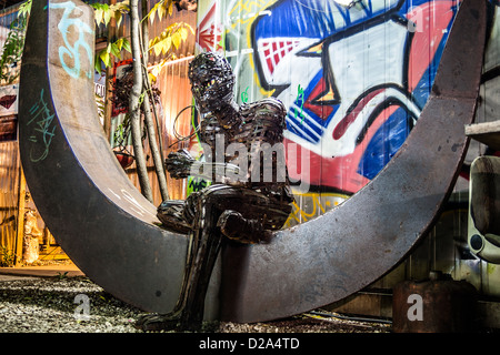 Metal sculpture representing a human figure sitting on a moon located in the backyard of a Tacheless berlin. Stock Photo