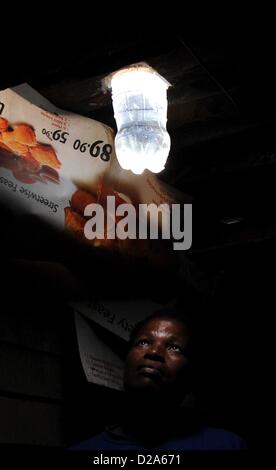 Johannesburg, South Africa. 18th January 2013.  Mavis Mabaso and her new bottle light on January 18, 2013, in Johannesburg, South Africa. The 'Lïtre of Light' project puts plastic bottles filled with water in shack roofs, providing light to shacks with no electricity during the day. Credit:  Gallo images / Alamy Live News Stock Photo