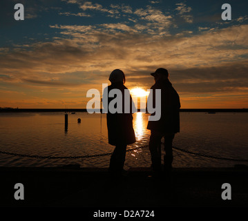 Two women chatting at sunset. Stock Photo