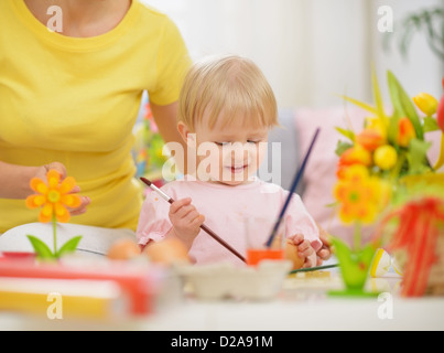 Happy mother and baby making Easter decorations Stock Photo