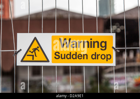 Warning, sudden drop sign, or wire security fence Stock Photo