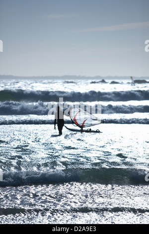 Man with wind sailing board in waves Stock Photo