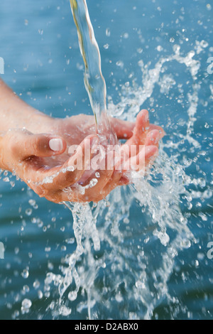 Woman catching water stream in hands Stock Photo
