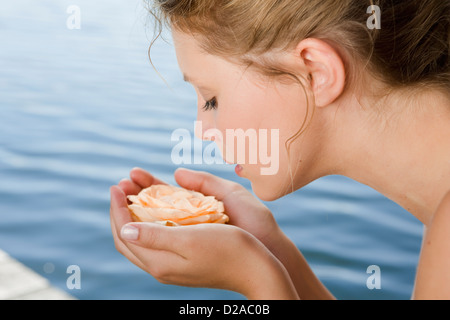 Woman cupping rose in hands Stock Photo