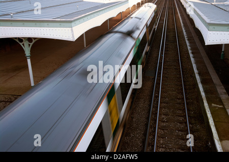 Railway Train Pulling Into a Station With Motion Blur On The Train Stock Photo