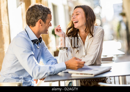 Couple laughing at sidewalk cafe Stock Photo