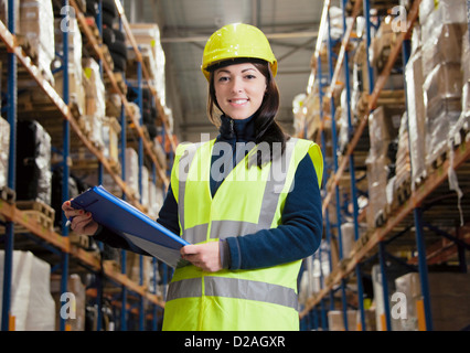 Worker holding clipboard in warehouse Stock Photo
