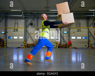 Worker balancing boxes in warehouse Stock Photo