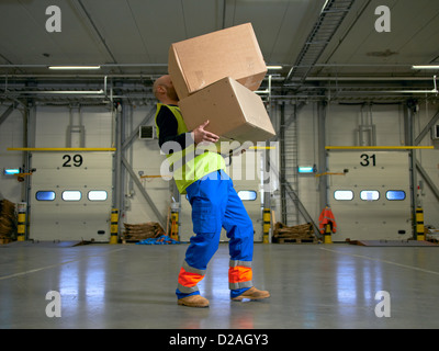 Worker carrying boxes in warehouse Stock Photo