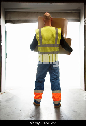 Worker carrying boxes in warehouse Stock Photo