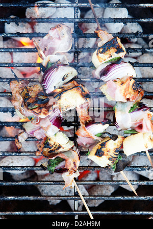 Skewers cooking on grill Stock Photo