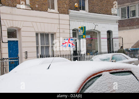 London, UK. 18/01/13. A union flag flies from a car that is covered in snow in Goodge Place, as snow falls in Central London. Stock Photo