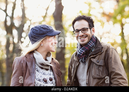 Smiling couple standing in forest Stock Photo