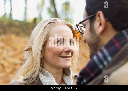 Smiling couple standing in forest Stock Photo