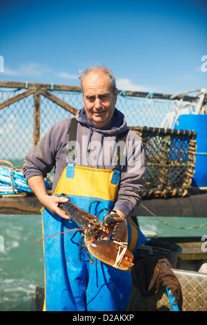 Fisherman holding lobster on boat Stock Photo