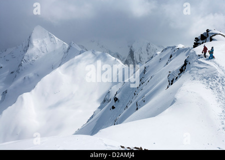 Snowboarders climbing snowy slope Stock Photo