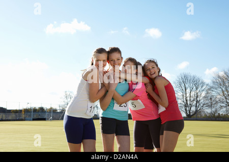 Runners smiling together in field Stock Photo