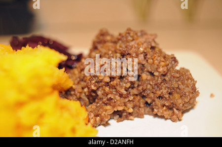 Haggis and swede with red cabbage . Haggis is a Scottish traditional supper served on Burns Night which is the 25th January Stock Photo