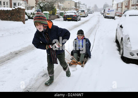 Cardiff, UK. Friday 18th January 2013. Two young boys make the best of the snow on their sledge in Cardiff, UK. All Schools  in Cardiff where closed today after heavy snow fall overnight that is to continue into the weekend. The UK Met Office has issued a severe weather warning for South East Wales. Stock Photo