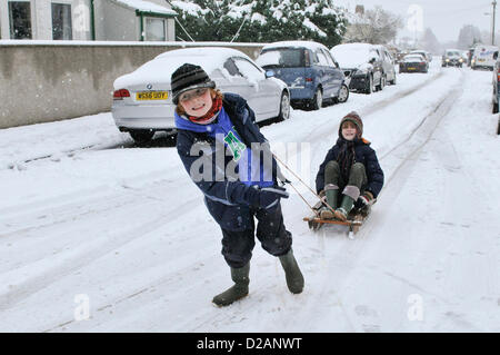 Cardiff, UK. Friday 18th January 2013. Two young boys make the best of the snow on their sledge in Cardiff, UK. All Schools  in Cardiff where closed today after heavy snow fall overnight that is to continue into the weekend. The UK Met Office has issued a severe weather warning for South East Wales. Stock Photo