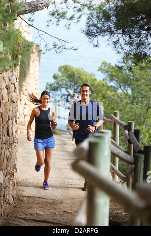 Couple running on dirt path Stock Photo