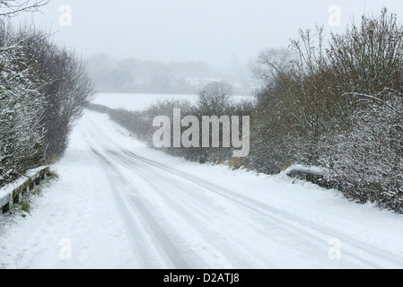 Snow covered road in extreme winter weather conditions UK Stock Photo