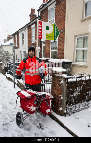 Royal Mail postman delivers mail in snowy winter weather. Reading, Berkshire, England, UK. Stock Photo