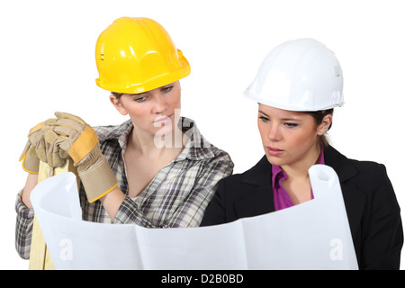 Construction worker looking at a plan with an engineer Stock Photo