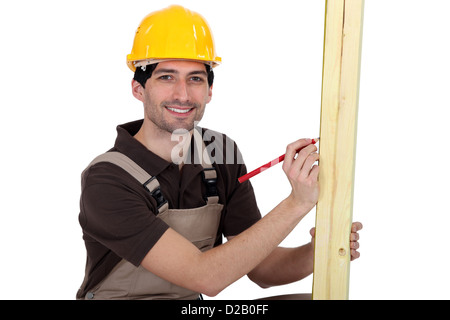 craftsman measuring a wooden piece Stock Photo