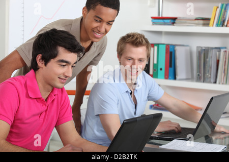 Young students working on their laptops in the university library Stock Photo