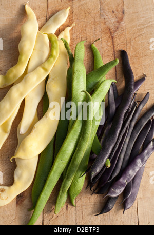 Organic runner beans in green,black and cream on a chopping board Stock Photo