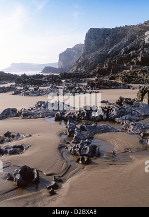 Mewslade Bay beach with rocky foreground and cliffs in distance Gower Peninsula Swansea County South Wales UK Stock Photo