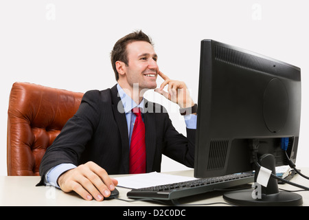 Handsome businessman smiling positively in office while using his computer. Stock Photo