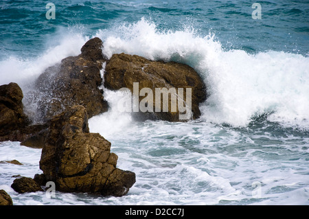 Wave crashing on rocky shore Stock Photo