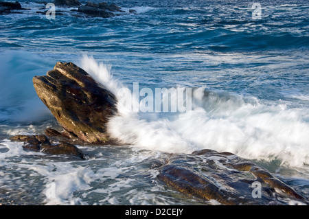 Wave crashing against rock on the beach Stock Photo