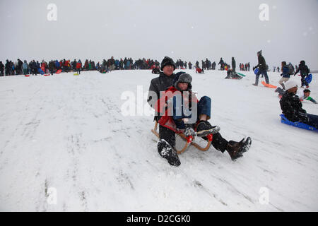 London, UK, Sunday 20th January 2013. As snow falls across the capital, Londoners spend their Sunday tobogganing down Parliament Hill on Hampstead Heath. London. Sunday 20th January 2013. Stock Photo