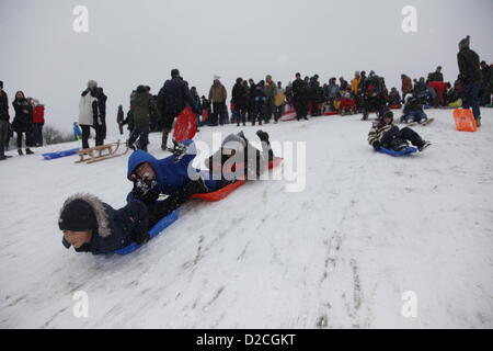 London, UK, Sunday 20th January 2013. As snow falls across the capital, Londoners spend their Sunday tobogganing down Parliament Hill on Hampstead Heath. London. Sunday 20th January 2013. Stock Photo