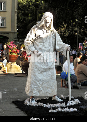 Mexican mime street performer in penitent sackcloth & ashes standing in flower garland in zocalo plaza Oaxaca de Juarez Mexico Stock Photo