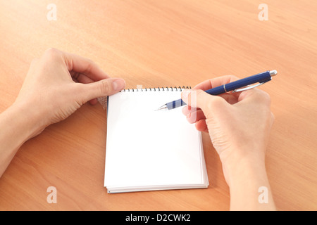 Woman hands writing in a notebook on a table in a white isolated background Stock Photo