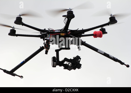 A radio controlled octocopter or drone outfitted with a camera taking photos of  ground objects for an aerial photography project Stock Photo