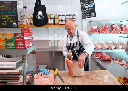 Butcher cutting meat at Drings Butchers, Royal Hill, Greenwich, South London, London, England, UK Stock Photo