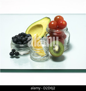 Selection of fruit and vegetables placed in glass pots cut out white background Stock Photo