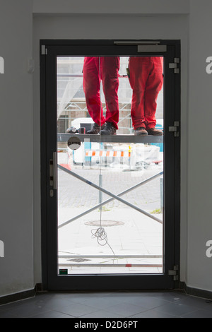Low section of two construction workers on scaffolding Stock Photo